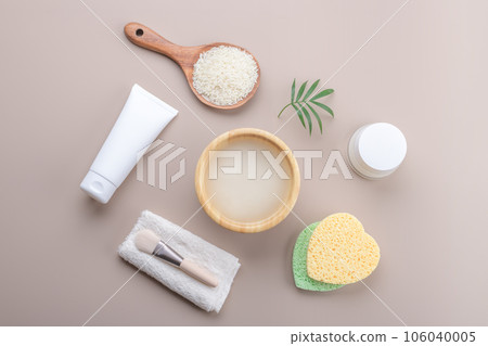 Homemade cosmetic rice water with beauty kit on beige background, top view copy space, home spa flat lay Homemade cosmetic rice water with beauty kit on beige background, top view copy space, home spa flat lay 106040005