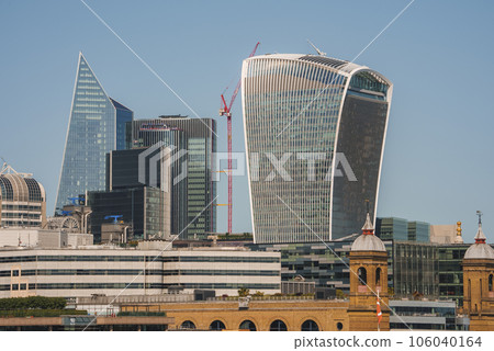 20 Fenchurch street tower amidst buildings. Downtown district in city on sunny day. Modern financial architecture with clear blue sky in background. 20 Fenchurch street tower amidst buildings. Downtown district in city on sunny day. Modern financial architecture with clear blue sky in background. 106040164