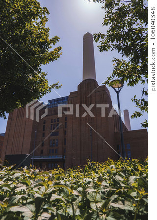 View of new Battersea Power Station amidst plants. Exterior of office building with sky in background. Tourist attraction in London during sunny day. 106040348