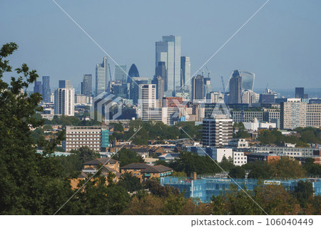 Modern skyscraper amidst residential district. Scenic view of crowded city with blue sky in background. High angle view of modern development in London. Modern skyscraper amidst residential district. Scenic view of crowded city with blue sky in background. High angle view of modern development in London. 106040449