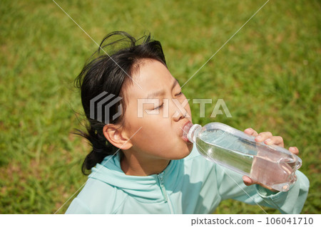A child drinking water in a midsummer park A child drinking water in a midsummer park 106041710