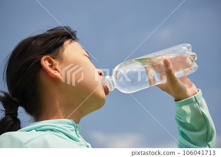 A child drinking water from a pet bottle under the scorching sun in midsummer A child drinking water from a pet bottle under the scorching sun in midsummer 106041713