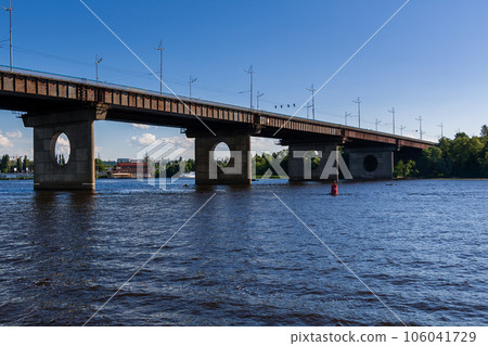 Bridge on a river against a blue sky and clouds Bridge on a river against a blue sky and clouds 106041729