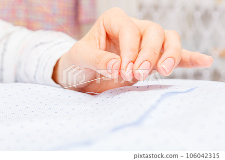 Female hands of a master tailor at work, a sewing machine needle 106042315