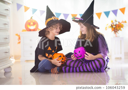 Kids in witch costume on Halloween trick or treat 106043259