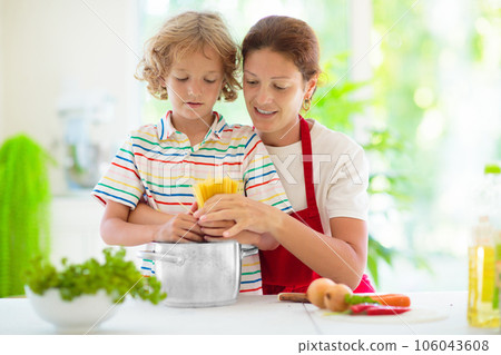 Family cooking dinner Mom and child cook spaghetti 106043608