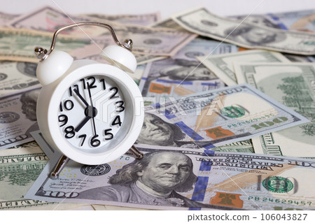 Clock on the background of bundle of dollars - texture, background 106043827