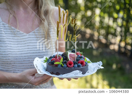 beautiful delicious Wedding cake with fresh wild berries and fruits Mrs Ms Sign on Top 106044380