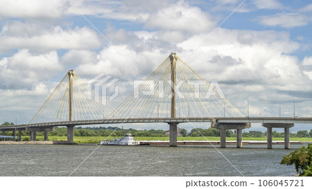 towboat with barges os passing under the Clark Bridge, a cable-stayed bridge across the Mississippi River between West Alton, Missouri and Alton, Illinois. 106045721