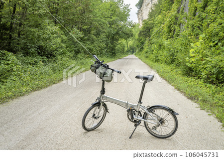 lightweight folding bike on Katy Trail near Rocheport, Missouri, summer scenery. The Katy Trail is 237 mile bike trail converted from an old railroad. lightweight folding bike on Katy Trail near Rocheport, Missouri, summer scenery. The Katy Trail is 237 mile bike trail converted from an old railroad. 106045731