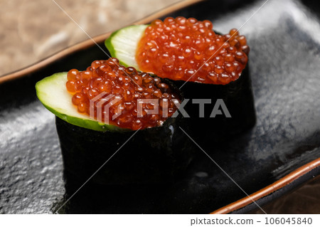 Two pieces of salmon roe on a black plate 106045840