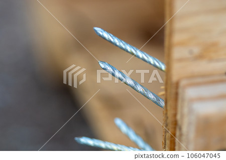Close up view of Nails coming out of a broken crate Close up view of Nails coming out of a broken crate 106047045