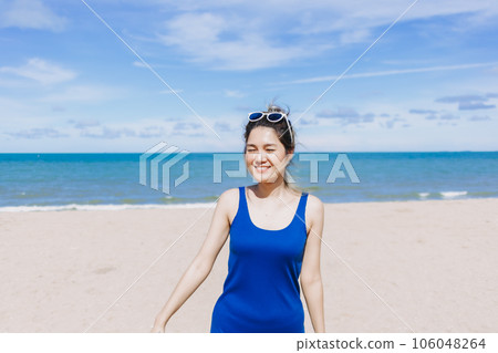 Happy and cheerful woman in blue dress on the sunny beach of Thailand. Happy and cheerful woman in blue dress on the sunny beach of Thailand. 106048264