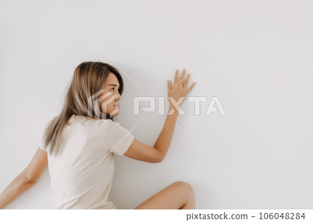 Funny woman lie on background try to spy and listen over the wall. Funny woman lie on background try to spy and listen over the wall. 106048284