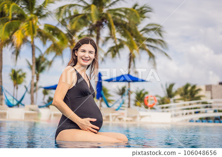 A serene moment captured as a pregnant woman after 40 enjoys a refreshing dip in the pool, embracing the beauty of her pregnancy journey with grace and tranquility 106048656