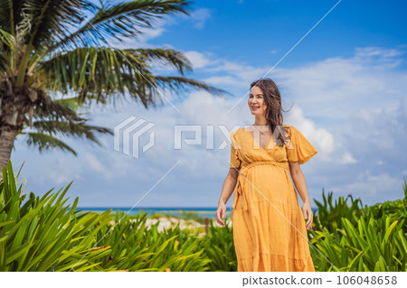 A radiant pregnant woman after 40 basking in the sun's warmth on a tropical beach, cherishing the serenity and bliss of her pregnancy journey A radiant pregnant woman after 40 basking in the sun's warmth on a tropical beach, cherishing the serenity and bliss of her pregnancy journey 106048658