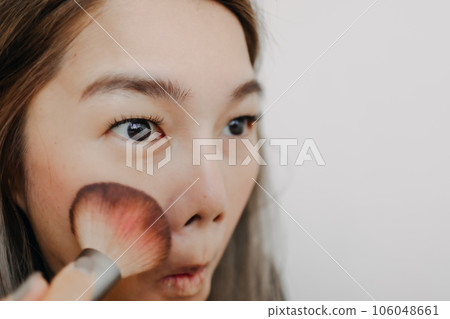 Close up of woman brushing her cheek face for make up. 106048661