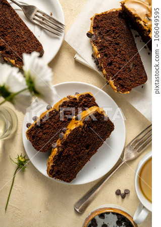 Chocolate loaf cake slices with coffee icing and chocolate chips, top view. Chocolate loaf cake slices with coffee icing and chocolate chips, top view. 106049595