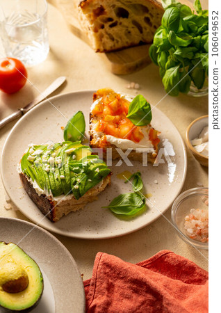 Avocado and salmon toasts with sourdough bread, sliced avocado, cream cheese and seeds, top view. Avocado and salmon toasts with sourdough bread, sliced avocado, cream cheese and seeds, top view. 106049652