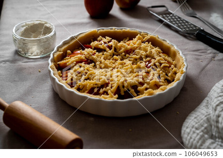 Cooking apple pie pastry. Raw pie with red apples in baking tin 106049653