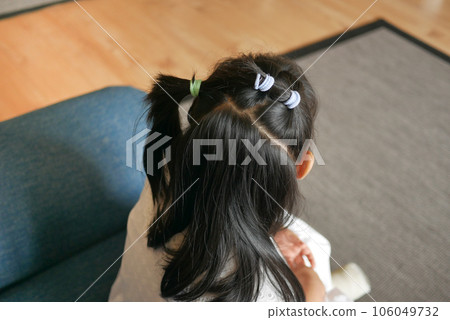 Beautiful ribbon is tied on a child hair  106049732