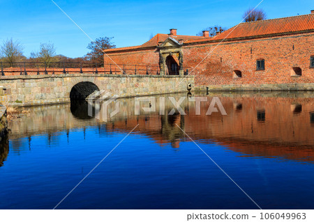 Brick stone bridge across the lake surrounding Frederiksborg castle in Hillerod, near Copenhagen, Denmark 106049963