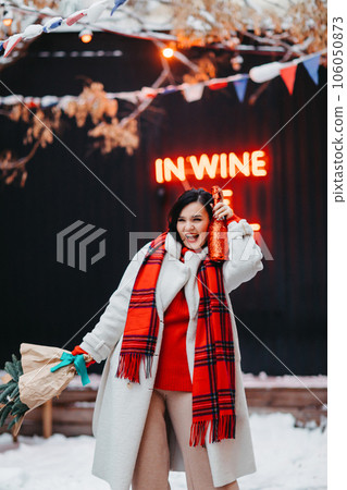 an attractive brunette woman with champagne and a bouquet of spruce branches. an attractive brunette woman with champagne and a bouquet of spruce branches. 106050873