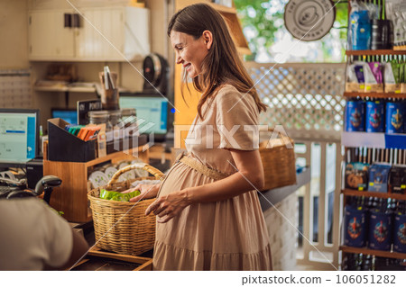 A glowing pregnant woman after forty makes a healthy choice as she selects organic vegetables and fruits at the vibrant organic market, prioritizing her well-being and her baby's health A glowing pregnant woman after forty makes a healthy choice as she selects organic vegetables and fruits at the vibrant organic market, prioritizing her well-being and her baby's health 106051282