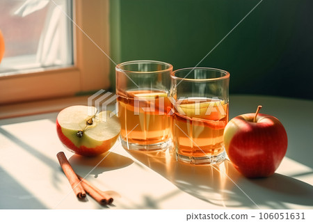 Seasonal drink cider from ripe apples, apple wine in small glasses and bottles on kitchen table Seasonal drink cider from ripe apples, apple wine in small glasses and bottles on kitchen table 106051631