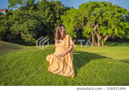 A serene and radiant pregnant woman after 40, surrounded by nature's beauty in the park, cherishing the journey of motherhood with a glowing smile A serene and radiant pregnant woman after 40, surrounded by nature's beauty in the park, cherishing the journey of motherhood with a glowing smile 106051966