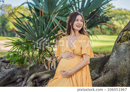 A serene and radiant pregnant woman after 40, surrounded by nature's beauty in the park, cherishing the journey of motherhood with a glowing smile A serene and radiant pregnant woman after 40, surrounded by nature's beauty in the park, cherishing the journey of motherhood with a glowing smile 106051967