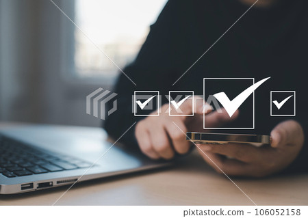 Businessman hold Smartphone with Taking assessment, questionnaire, evaluation, online survey online exam Choosing the right answer in exam by filling out the online survey form,Answer  test questions 106052158