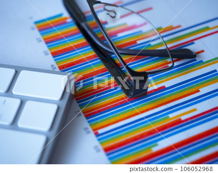 Graphs, keyboard and glasses on the table 106052968