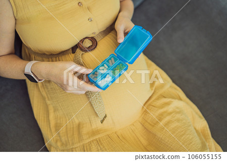 Prenatal Vitamins. Portrait Of Beautiful Smiling Pregnant Woman Holding Pill Box, Taking Supplements For Healthy Pregnancy While Sitting On Couch At Home, Free Space Prenatal Vitamins. Portrait Of Beautiful Smiling Pregnant Woman Holding Pill Box, Taking Supplements For Healthy Pregnancy While Sitting On Couch At Home, Free Space 106055155