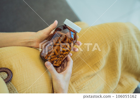 Prenatal Vitamins. Portrait Of Beautiful Smiling Pregnant Woman Holding Transparent Glass Jar With Pills, Taking Supplements For Healthy Pregnancy While Sitting On Couch At Home, Free Space Prenatal Vitamins. Portrait Of Beautiful Smiling Pregnant Woman Holding Transparent Glass Jar With Pills, Taking Supplements For Healthy Pregnancy While Sitting On Couch At Home, Free Space 106055162