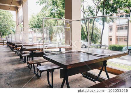 Group of plastic partition setting on table in canteen for reduce and protection the COVID-19 virus spreads in pandemic. Social distancing concept. Group of plastic partition setting on table in canteen for reduce and protection the COVID-19 virus spreads in pandemic. Social distancing concept. 106055956