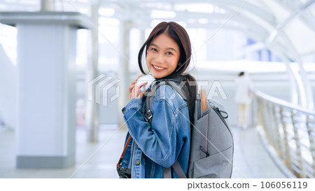 Young asian woman using headphone for listening nice music and walking in city 106056119