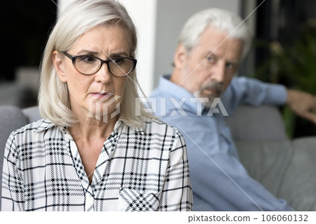 Stressed mature wife feeling frightened with annoyed older husband behind 106060132