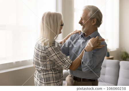 Happy senior couple training social dance at home, enjoying music 106060238