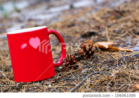 Red ceramic cup inscription love with hot drink beverage,autumn grass 106061086