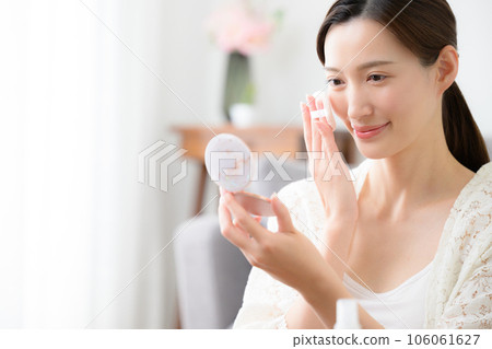 Photo of beautiful woman putting makeup on 106061627