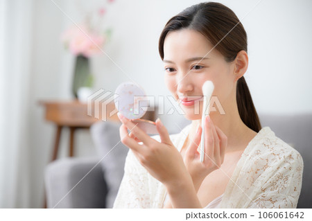 稍微俯瞰一張美麗女人用刷子塗抹腮紅的照片 稍微俯瞰一張美麗女人用刷子塗抹腮紅的照片 106061642