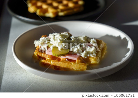 Waffle pizza with ham and pickled cucumbers and cheese. Hybrid food, piffle 106061751