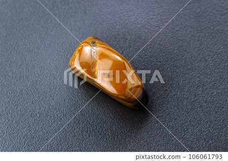 Natural mineral gem stone Tiger eye gemstone on black background close-up. 106061793
