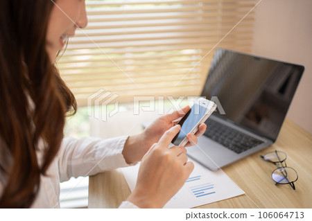 Young women use smartphones to play games or watch video clips to relax after a break from completing homework. Use mobile phones to create entertainment and happiness. Young women use smartphones to play games or watch video clips to relax after a break from completing homework. Use mobile phones to create entertainment and happiness. 106064713