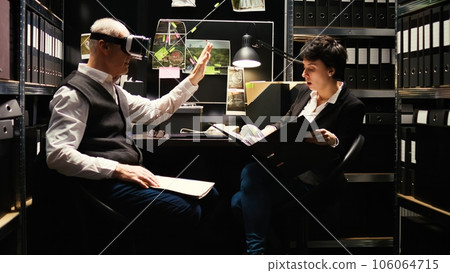 Senior inspector using vr glasses to reenact crime scene in police incident room, working on criminal case with agent. Male private investigator retracing killer steps with virtual reality headset. 106064715