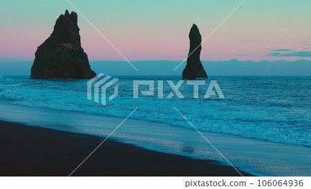 Atlantic shore with majestic rocks on reynisfjara beach and reynisfjall mountain, nordic black sand beaches. Icelandic coastline scenery with ocean waves, pink sky. Handheld shot. 106064936