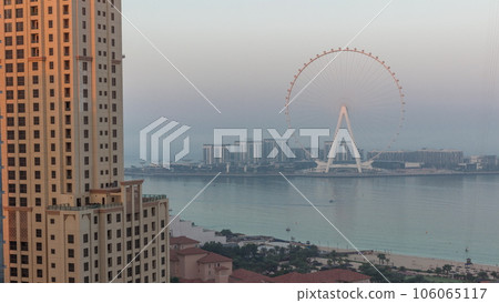 Bluewaters island with modern architecture and ferris wheel aerial night to day timelapse. Bluewaters island with modern architecture and ferris wheel aerial night to day timelapse. 106065117