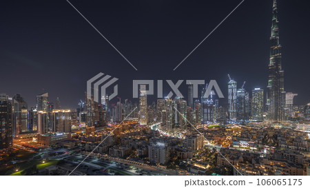 Panorama showing Dubai's business bay towers aerial night timelapse. Rooftop view of some skyscrapers Panorama showing Dubai's business bay towers aerial night timelapse. Rooftop view of some skyscrapers 106065175