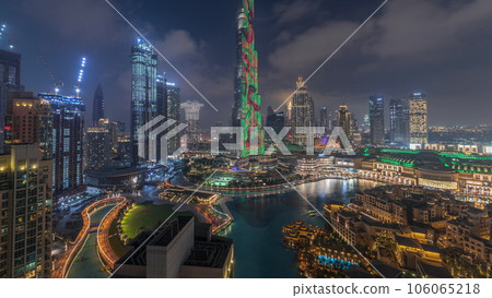 Skyscrapers rising above Dubai downtown day to night timelapse surrounded by modern buildings aerial top view Skyscrapers rising above Dubai downtown day to night timelapse surrounded by modern buildings aerial top view 106065218
